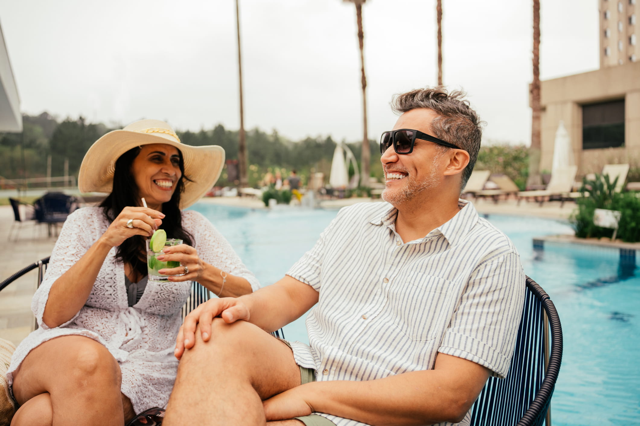 Stel in gesprek bij het zwembad van een hotel tijdens een ontspannen vakantie