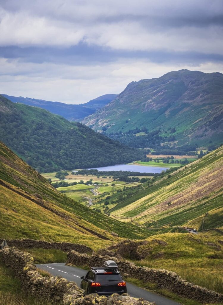 Auto rijdt door bergachtig landschap in Lake District Engeland tijdens roadtrip